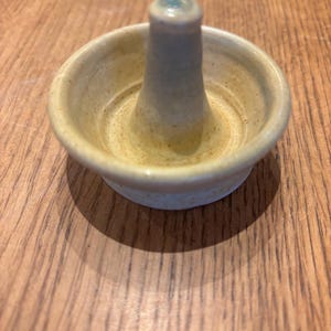 May include: A set of three ceramic mugs with a speckled, matte finish. Each mug features a different color: light blue, cream, and gray. The mugs have a simple, modern design and a comfortable handle.