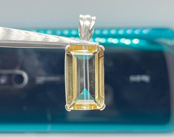 May include: A silver pendant with a rectangular, faceted, yellow gemstone.