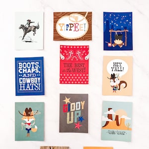 May include: A set of ten illustrated cards with a western theme. The cards feature phrases like "Giddy Up", "Yippee!" and "Boots, Chaps, and Cowboy Hats!"  The cards are printed on white cardstock with colourful illustrations.