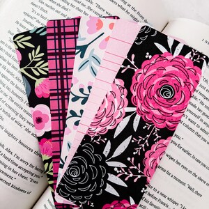 May include: A set of six pink and black floral patterned bookmarks. The bookmarks are made of paper and have a variety of floral designs. The bookmarks are perfect for adding a touch of elegance to any book.