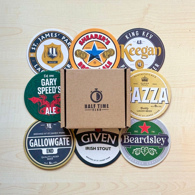 May include: A collection of nine round coasters featuring various brewery logos and names, including "Gary Speed's", "Gallowgate", "Given", "Beardsley", "Shearer's", "King Kev Keegan", "Gazza", and "St. James Park". The coasters are arranged in a circle around a brown box with the words "Half Time Club" printed on it.