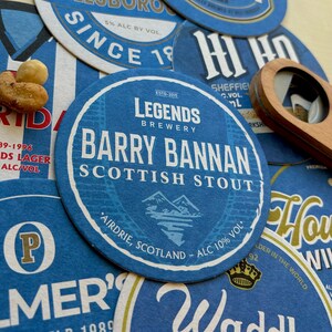 K&ouml;nnte beinhalten: Ein runder Bieruntersetzer in Blau und Wei&szlig; mit dem Text "Legends Brewery" und "Barry Bannan Scottish Stout" in wei&szlig;er Schrift. Der Untersetzer enth&auml;lt auch den Text "Airdrie, Scotland - ALC 10% Vol."