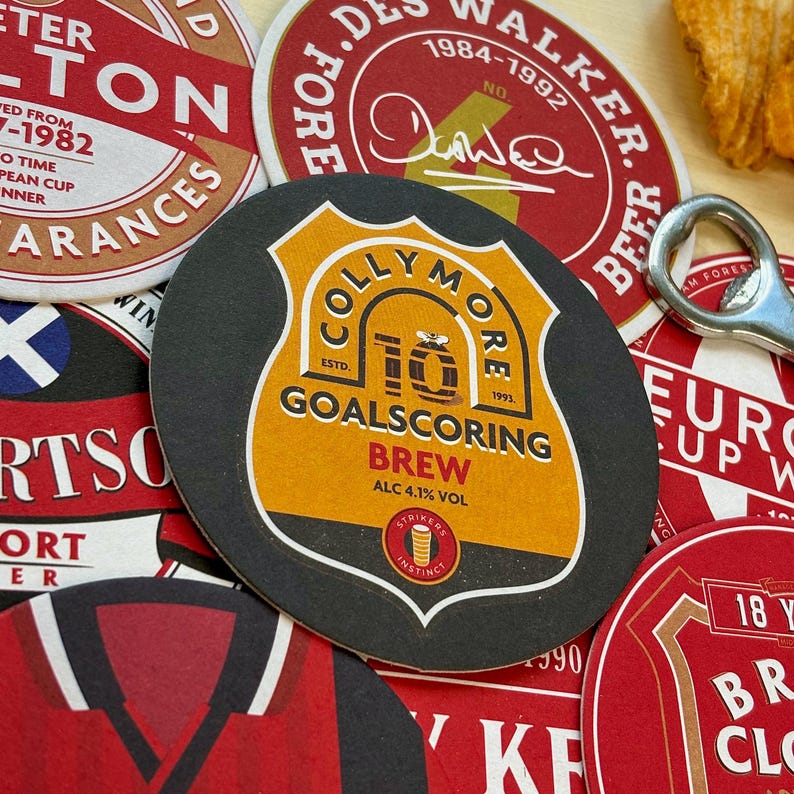 May include: A collection of colorful round coasters with various designs. One coaster features a black and yellow logo with the text "Colly More" and "Goalscoring Brew" with a bee illustration. Another coaster has a red background with the text "J.D. Walker Beer" and "1984-1992".