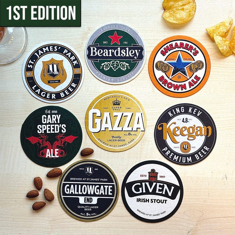 May include: A set of ten round, colorful coasters featuring different beer brands. The coasters are made of cardboard and have a variety of designs, including a star, a dragon, and a castle. The coasters are arranged in a circle on a wooden surface.