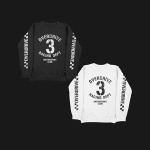 May include: Two sweatshirts with a racing theme. One is black with white text and the other is white with black text. Both have the words "Overdrive Racing Dept" and the number "3" on the front. The sleeves have a checkered pattern with the word "Overdrive" repeated.