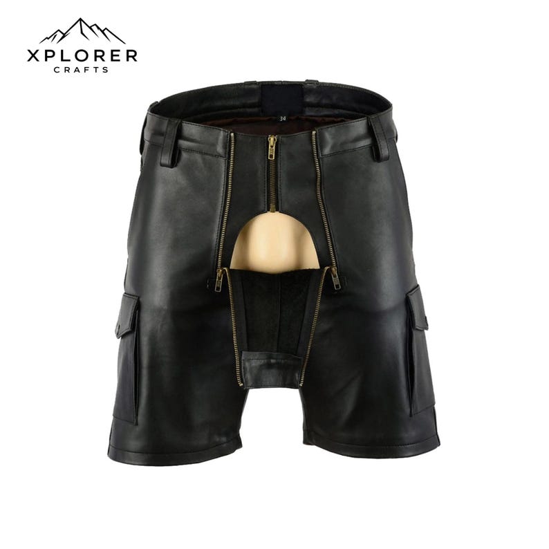 K&ouml;nnte beinhalten: Schwarze Leder-Shorts mit einem einzigartigen Design, das einen Frontrei&szlig;verschluss und Cargotaschen aufweist. Die Shorts haben einen markanten Schnitt und sind mit dem Logo "XPLORER CRAFTS" versehen.