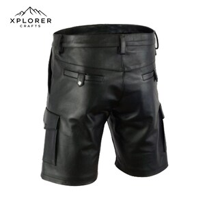 K&ouml;nnte beinhalten: Schwarze Leder-Shorts mit Cargotaschen und G&uuml;rtelschlaufen. Die Shorts haben einen Knopfverschluss und ein klassisches Design. Das Markenlogo "XPLORER CRAFTS" ist oben links sichtbar.