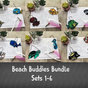 Op de afbeelding: Zes sets met gebrandschilderde zeedieren-kits. Elke set bevat een genummerd sjabloon en een set kleurrijke glasstukken om een zeedier te maken. De sets bevatten een vis, een octopus, een walvis, een schildpad, een zeepaardje en een clownvis.