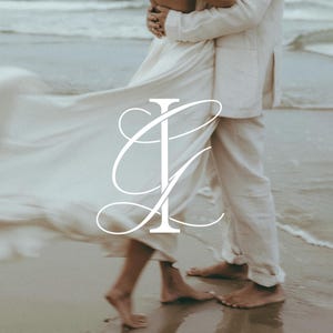 Puede incluir: Un logotipo de monograma blanco que presenta las letras G y L entrelazadas en una fuente serif decorativa, superpuesto en una fotografía de dos personas con ropa clara de pie en una playa de arena cerca de las olas del mar.