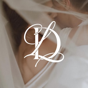 Może przedstawiać: Biały kaligraficzny monogram przedstawiający splecione litery D i L, wykonane płynną, elegancką czcionką skryptową. Białe logo jest wyśrodkowane i nałożone na miękkie, rozmyte tło przedstawiające osobę w białym ubraniu.