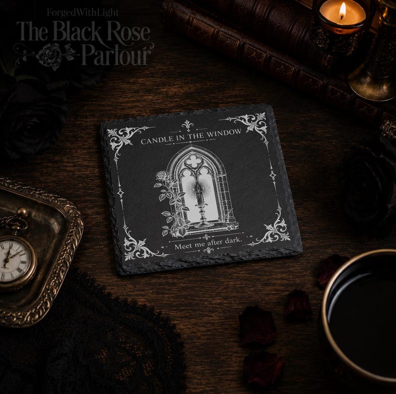 Pu&ograve; includere: Un sottobicchiere quadrato in ardesia nera con un'incisione bianca raffigurante una finestra gotica ad arco con una candela accesa e un ramo di rose. Il testo recita CANDLE IN THE WINDOW e Meet me after dark, con decorazioni angolari.