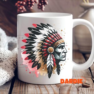May include: White ceramic mug with a colorful illustration of a Native American chief wearing a headdress with red, white, and black feathers. The illustration is surrounded by gold glitter and pink watercolor splatters.