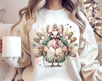 May include: A cream-coloured sweatshirt with a colourful turkey design. The turkey has a pink bow, pink and green feathers, and gold glitter accents. The design is centered on the front of the sweatshirt, creating a festive and eye-catching look.