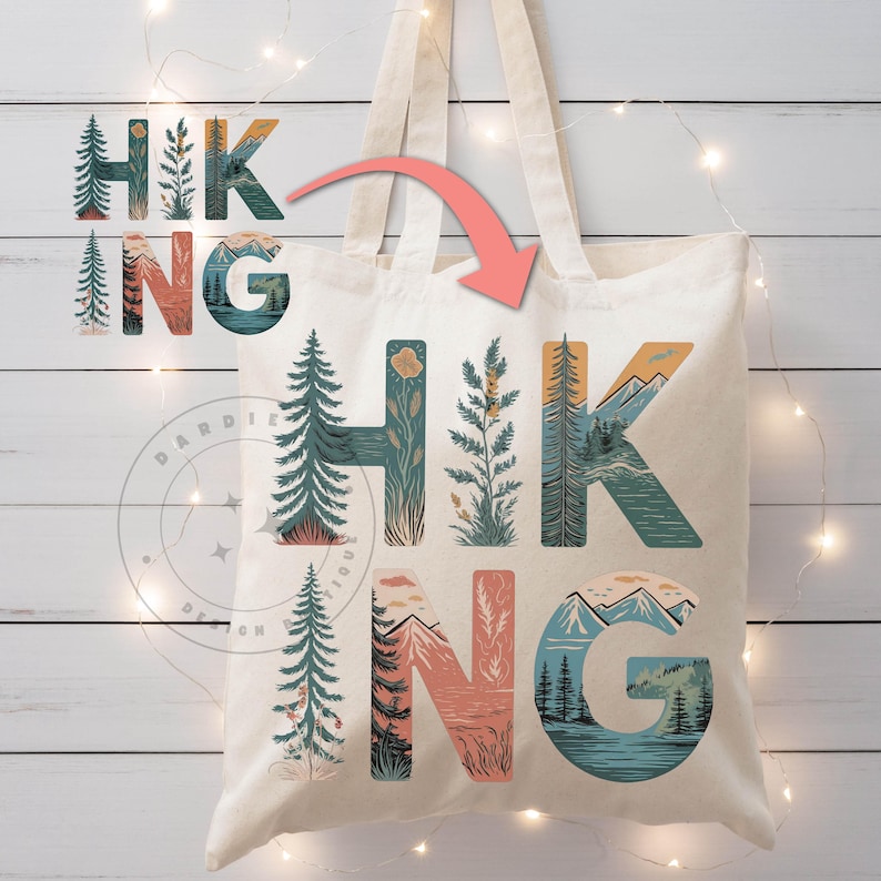 Op de afbeelding: Een witte canvas tote bag met het woord "HIKING" bedrukt in kleurrijke letters. Elke letter is gevuld met een natuursc&egrave;ne, waaronder bergen, bomen en bloemen.