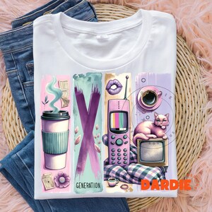 May include: White t-shirt with a graphic design featuring a pink phone, a cup of coffee, a cat, a television, and the text "GENERATION".