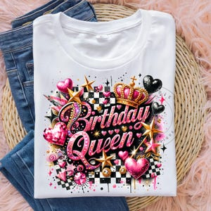 May include: White t-shirt with a pink and gold design that says "Birthday Queen". The design features a crown, hearts, stars, and a checkered pattern.