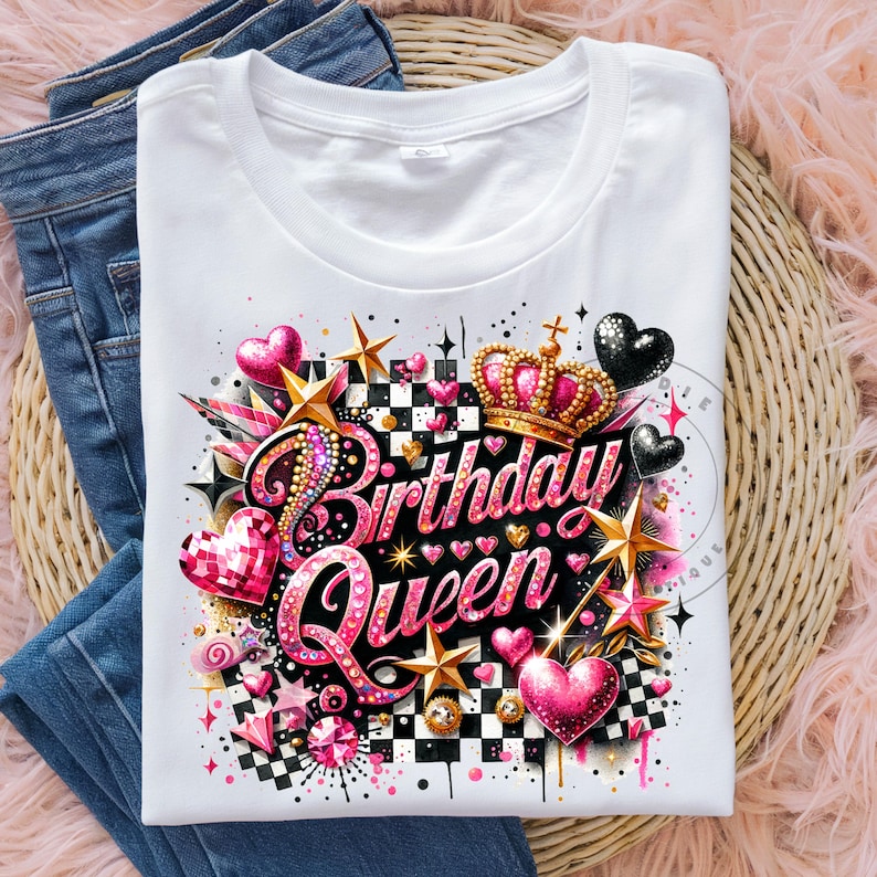 May include: White t-shirt with a pink and gold design that says "Birthday Queen". The design features a crown, hearts, stars, and a checkered pattern.
