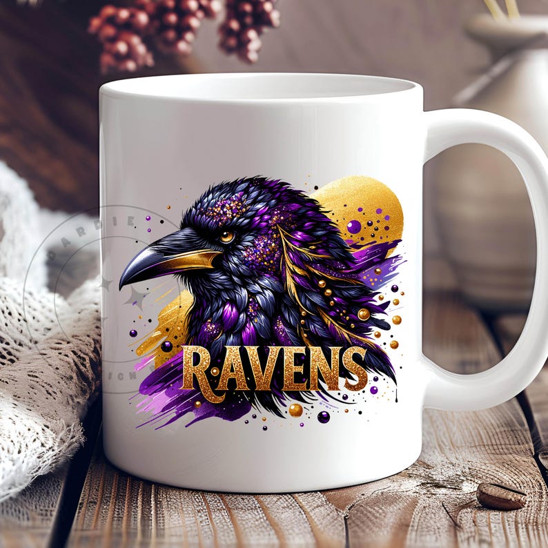 May include: White ceramic mug featuring a detailed illustration of a raven with purple, gold, and black feathers. The word "RAVENS" is displayed in gold lettering below the raven. The mug has a white handle and a glossy finish.
