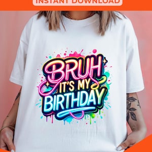 以下が含まれることがあります： 「Bruh it's my birthday」と書いてあるカラフルなグラフィックデザインが施された白いTシャツ。グラフィックはネオン効果があり、カラフルなペイントの飛沫で囲まれています。