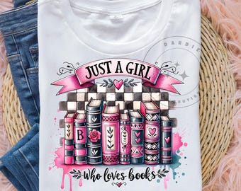 May include: White t-shirt with a graphic design featuring a stack of books in pink, black, and white. The design includes the text "JUST A GIRL" on a pink banner and "who loves books" below the books. The shirt is displayed on a woven surface with blue jeans.