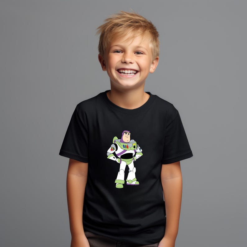 May include: Black t-shirt featuring a cartoon illustration of Buzz Lightyear from Toy Story. The character is depicted in his signature white, green, and purple spacesuit, with his arms at his sides. The shirt is worn by a smiling child.