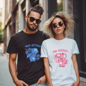 May include: Black and white t-shirts featuring cartoon character designs. The black shirt reads "Her Stitch" with a blue character and flower. The white shirt says "His Angel" with a pink character and flower. Both have short sleeves.