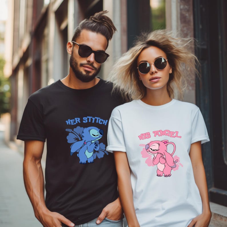 May include: Black and white t-shirts featuring cartoon character designs. The black shirt reads "Her Stitch" with a blue character and flower. The white shirt says "His Angel" with a pink character and flower. Both have short sleeves.