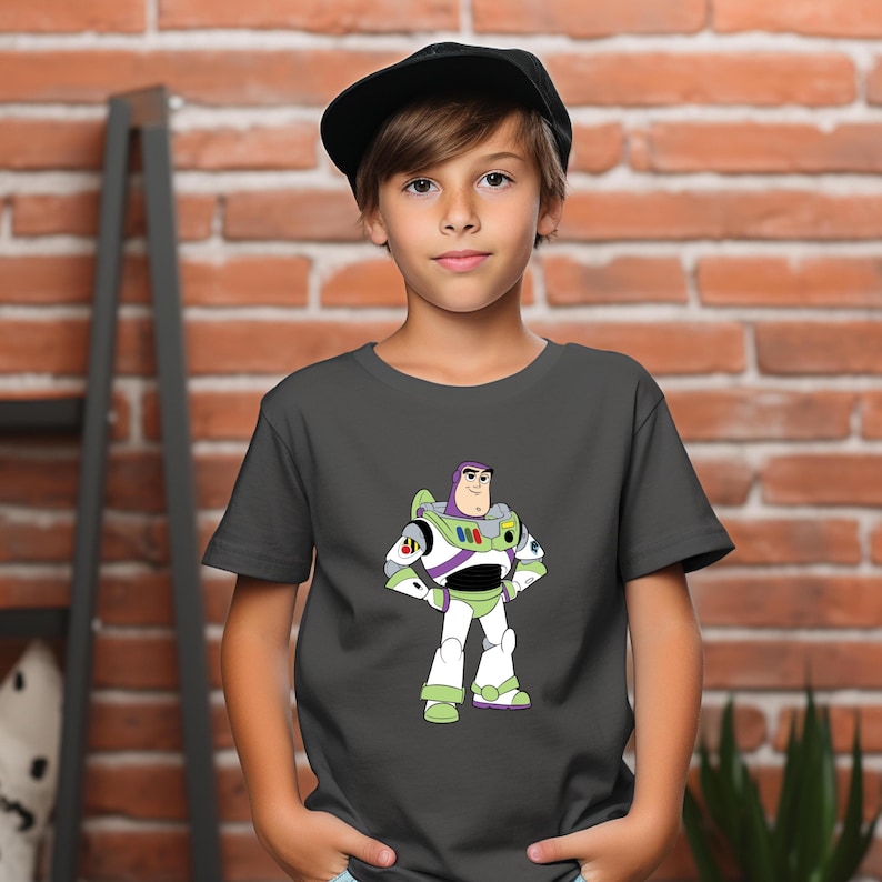 May include: A charcoal gray t-shirt featuring a graphic of Buzz Lightyear from Toy Story. The cartoon character is depicted in his signature white, green, and purple spacesuit. The shirt is short-sleeved and appears to be made of a soft material.