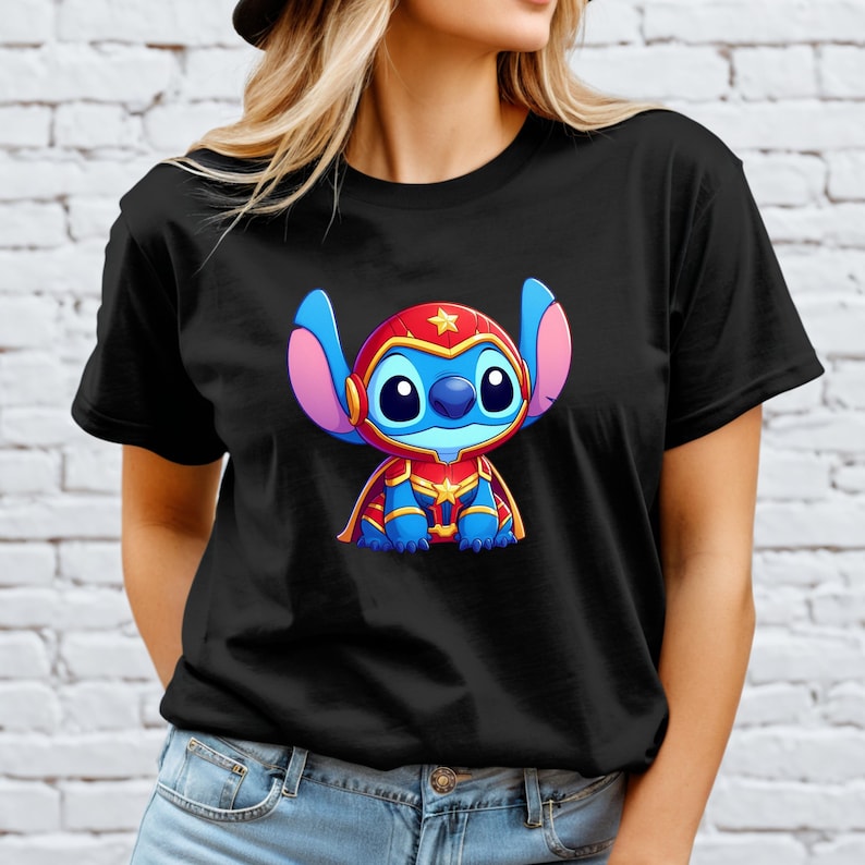 May include: Black t-shirt featuring a cartoon character in a superhero costume. The character is blue with large ears, wearing a red helmet with a gold star, and a red and gold uniform. The design is centered on the shirt.