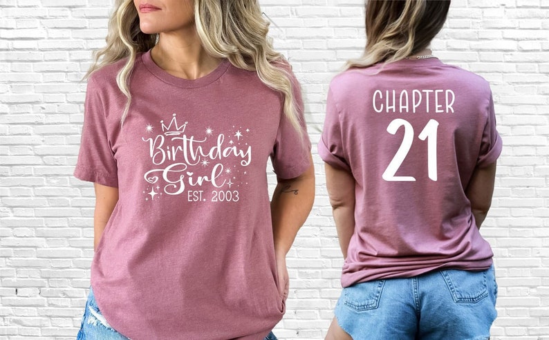 Puede incluir: Una camiseta rosa con el texto "Birthday Girl Est. 2003" y una corona en la parte delantera. La parte posterior de la camiseta tiene el texto "Chapter 21".