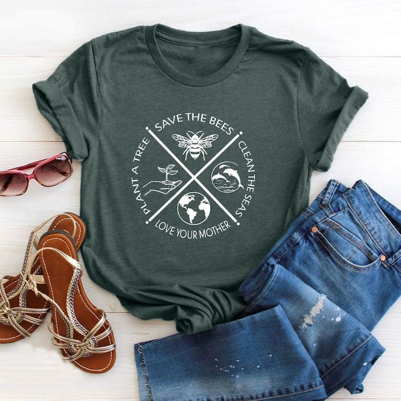 May include: A green t-shirt with a white graphic design. The graphic features a bee, a tree, a globe, and dolphins. The text reads "Save the Bees, Plant a Tree, Clean the Seas, Love Your Mother."
