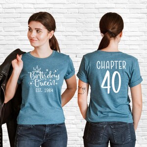 Pode incluir: Uma camiseta azul com o texto "Birthday Queen Est. 1984" na frente e "Chapter 40" nas costas.