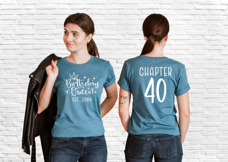 Pode incluir: Uma camiseta azul com o texto "Birthday Queen Est. 1984" na frente e "Chapter 40" nas costas.