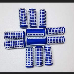 May include: A collection of eleven cylindrical hair rollers, each featuring a blue plastic core encased in a white grid-patterned mesh sleeve. The rollers are arranged in a cross-like formation, showcasing their uniform design and construction.