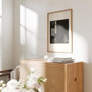 Metallicas 1991 The Black Album artwork hanging on the wall in a wood frame