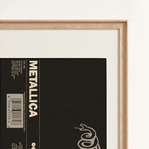 Close up of vintage Metallicas 1991 The Black album reproduction print  in an antique gold frame