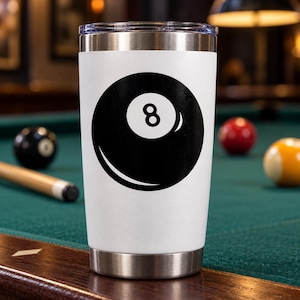 May include: A white stainless steel tumbler with a clear lid featuring a large black and white graphic of an eight ball. The design includes a solid black circle with a white center containing the number eight, positioned on the front of the cup.