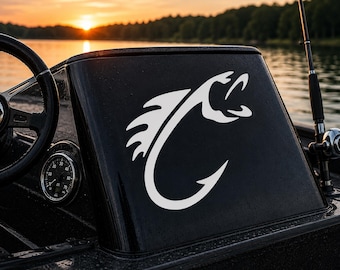 May include: A white vinyl decal featuring a stylized fish graphic integrated into the shape of a fishing hook, applied to the black console of a boat. The design shows a fish with an open mouth curving into the hook's shank and point.