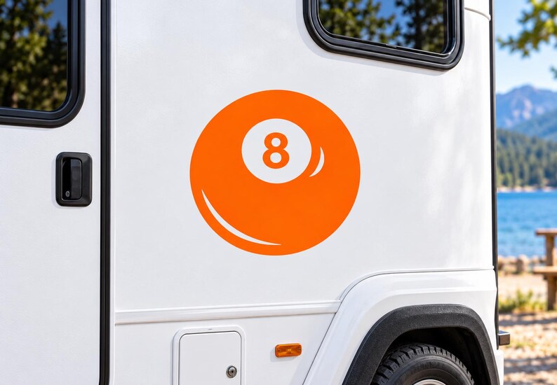 May include: A bright orange circular decal featuring a white number eight in the center, designed to resemble a billiard ball. The graphic is applied to the smooth white exterior side panel of a vehicle, positioned near a black window frame.