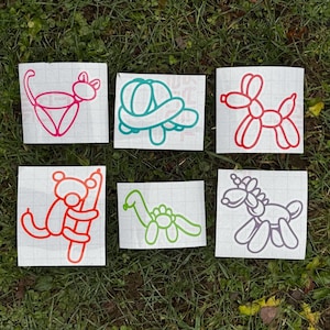 May include: Six vinyl decals on white grid transfer paper featuring balloon animal designs. The set includes a pink cat, a teal turtle, a red dog, an orange monkey on a pole, a lime green long-necked dinosaur, and a purple unicorn silhouette.