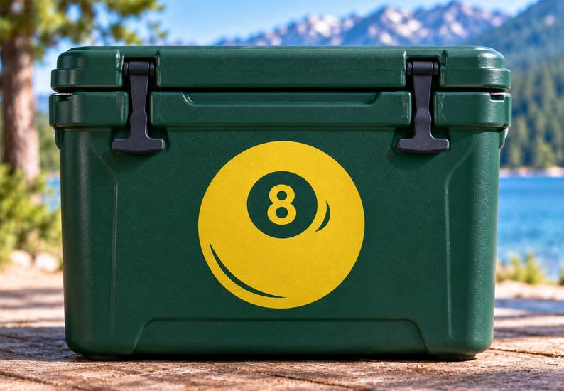 May include: A dark green rectangular cooler featuring a large yellow graphic of an eight ball on the front center. The cooler has a solid lid with two black rubber latches on the top corners and a smooth, durable exterior finish for storage.
