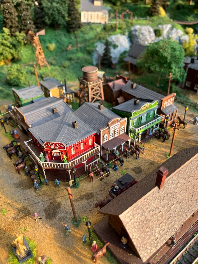 Pu&ograve; includere: Un modello in miniatura di una citt&agrave; del Far West con edifici come un saloon, una banca e un negozio generico. Il modello include una torre d'acqua in legno, un binario ferroviario e diverse figure di persone e cavalli.