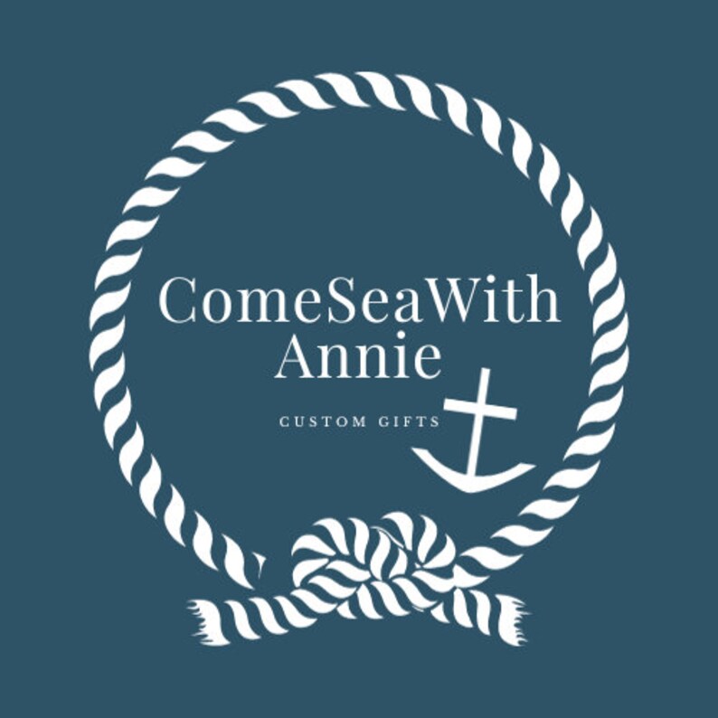May include: White rope circle with a knot at the bottom. The rope circle has the text "ComeSeaWith Annie" and "CUSTOM GIFTS" inside. A white anchor with a cross at the top is inside the rope circle.