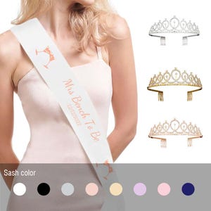 May include: White satin sash with the text "Mrs. Bench To Be 2021/2022" in rose gold lettering. The sash features a champagne glass design.  A selection of eight different sash colors are shown below the sash.