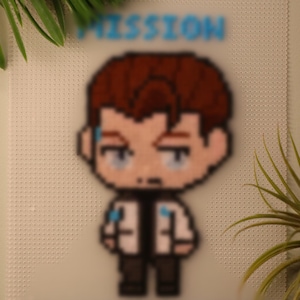 以下が含まれることがあります： 茶色の髪と白い白衣を着た漫画のキャラクターのピクセルアート画像。キャラクターは右を見て、真剣な表情をしています。「MISSION ACCOMPLISHED」というテキストがキャラクターの上に青い文字で書かれています。