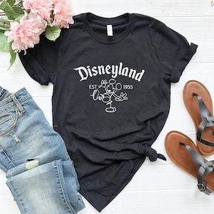 May include: Black t-shirt with a white graphic of Mickey Mouse and the text "Disneyland Est. 1955".