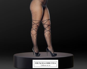 May include: Black fishnet tights featuring a high-waisted design, crisscross leg detailing, and a bow pattern above the ankles. The tights are paired with black high-heeled pumps. A label on the base displays the text FRENCH GAMBETTES Collants & cie.