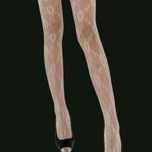 Può includere: Collant di pizzo bianco con un motivo floreale. I collant sono indossati da una persona con pantaloncini neri e scarpe nere. L'immagine include il testo "French Gambettes Collants & cie".