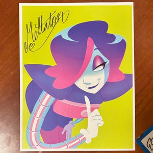 May include: A colorful print featuring a cartoon character with purple hair, blue skin, and a pink and blue outfit. The character is smiling and pointing a finger. The print has the name "Mettaton" written in a cursive font on a yellow background.