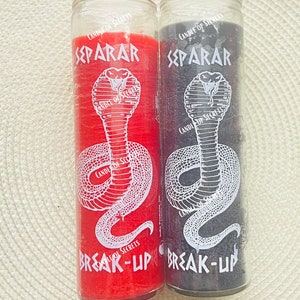 May include: Two glass candle jars with a snake design and the words "Separar" and "Break-Up" printed on them. The candle on the left is red and the candle on the right is black.